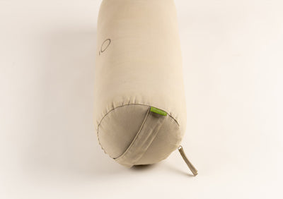 Beige yoga bolster,side view with logo in the middle. and a handle.