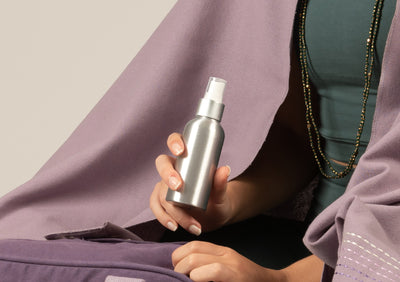 A woman holding lavender mood spray and putting it in a bag.